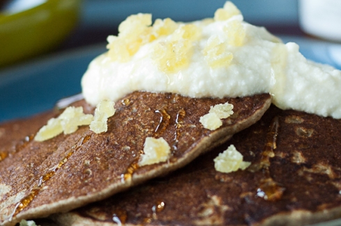 close-up buckwheat pancakes with ricotta, honey, and ginger topping